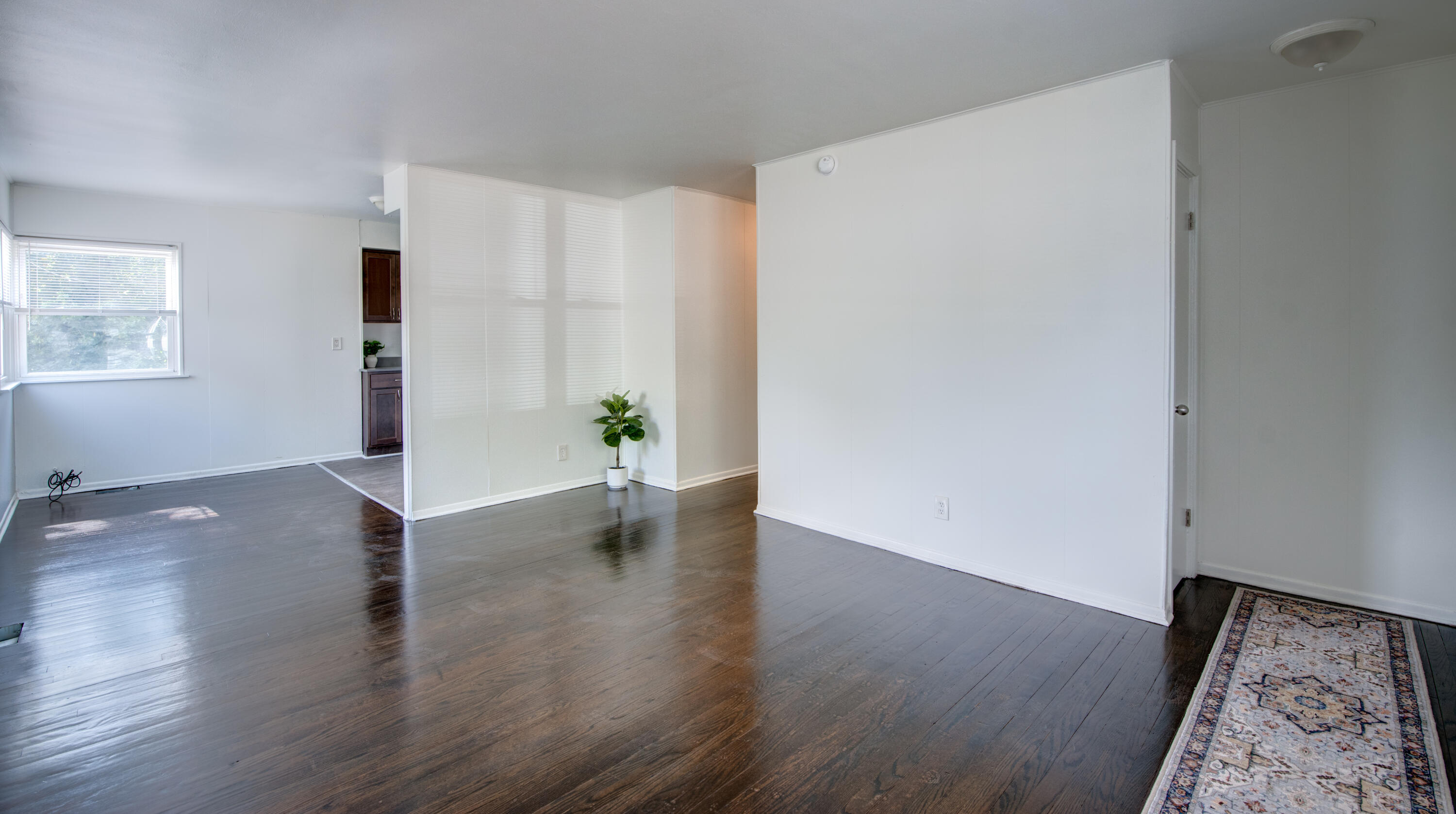 4409 East 11th Avenue Gary, IN 46403 - Photo 8 of 32 a view of an empty room with wooden floor and a window