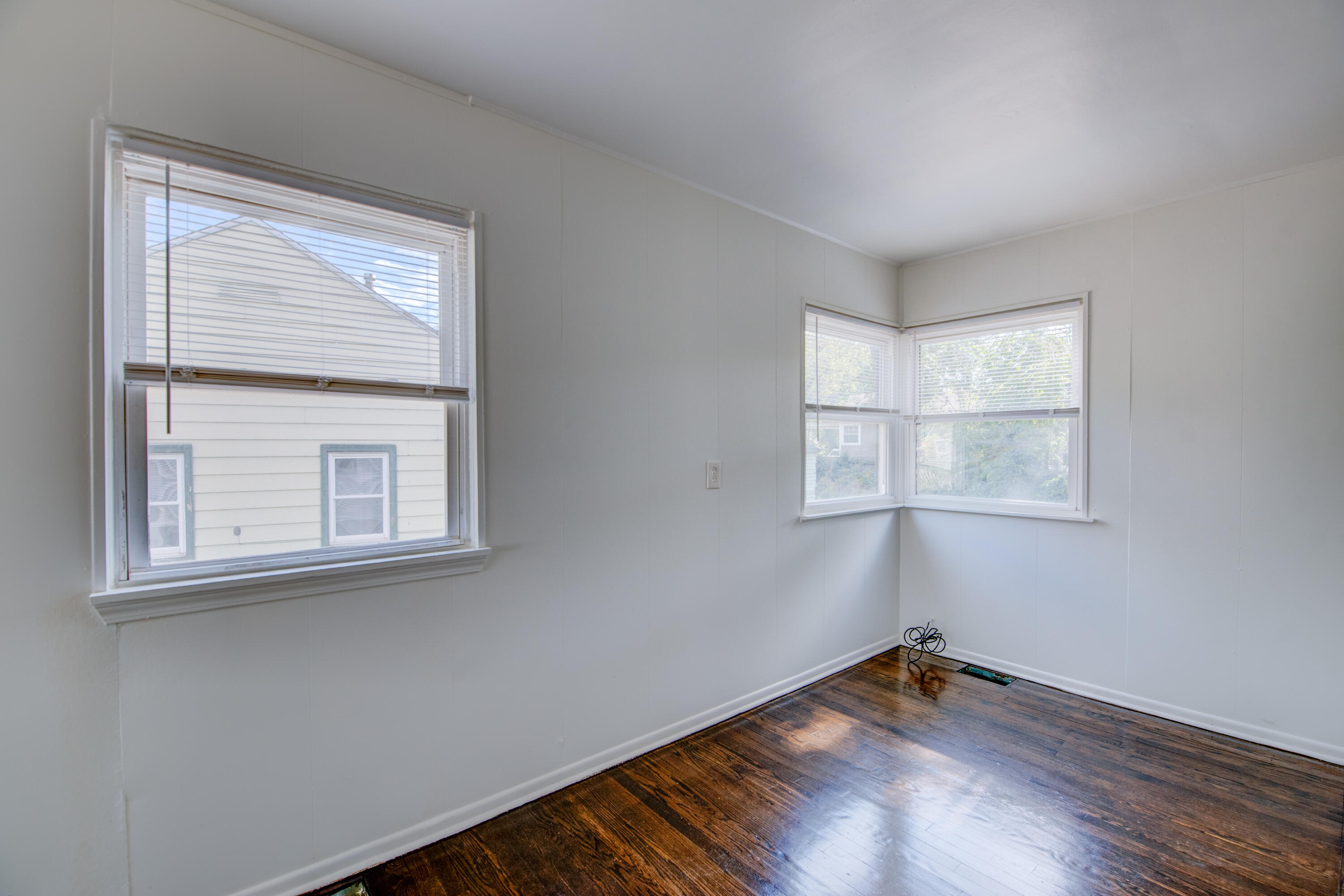 4409 East 11th Avenue Gary, IN 46403 - Photo 9 of 32 an empty room with wooden floor and windows