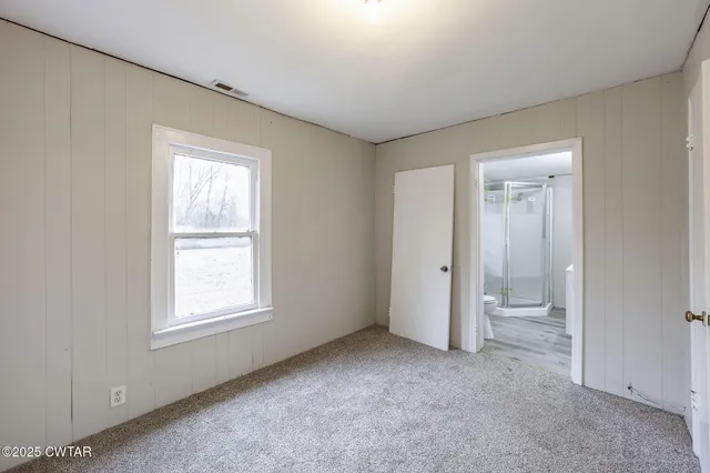 an empty room with windows and closet
