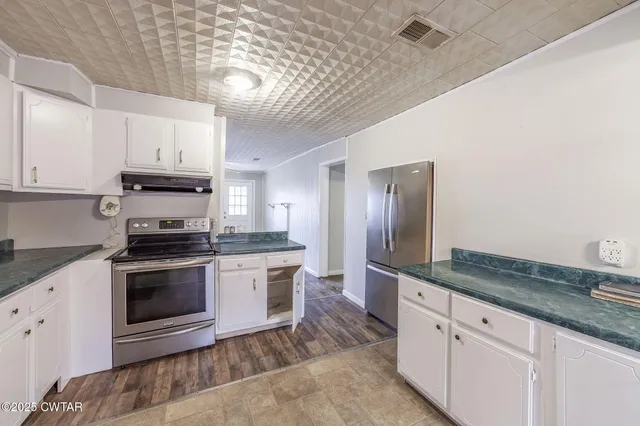 a kitchen with stainless steel appliances granite countertop a sink and a stove