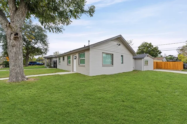 a view of a house with backyard and trees