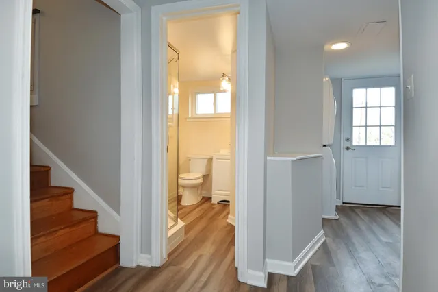 a view of a hallway with wooden floor and staircase