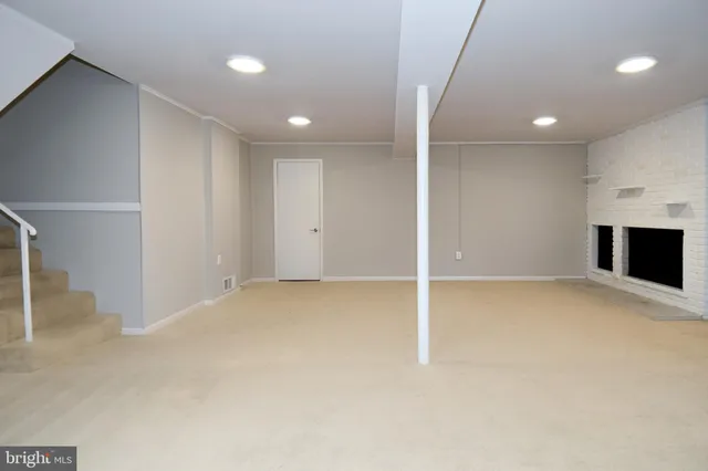 an empty room with windows and fireplace