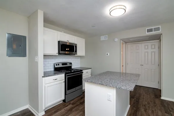 a kitchen with granite countertop a stove top oven and sink