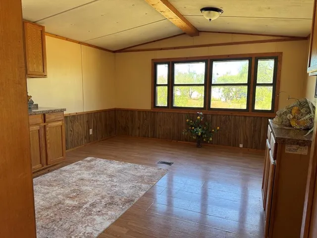 a view of a livingroom with wooden floor and furniture