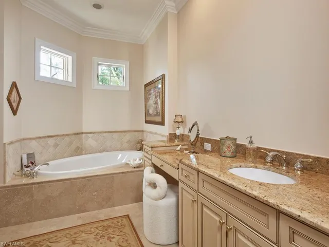 a bathroom with a granite countertop sink and a bathtub