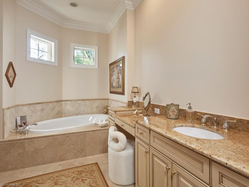 165 Broad Avenue South Naples, FL 34102 - Photo 16 of 18 a bathroom with a granite countertop sink and a bathtub