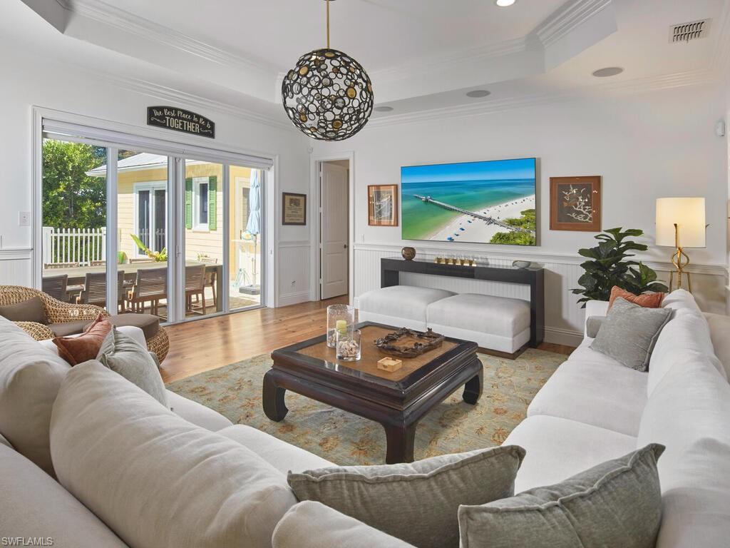 165 Broad Avenue South Naples, FL 34102 - Photo 6 of 18 a living room with furniture a chandelier and a large window