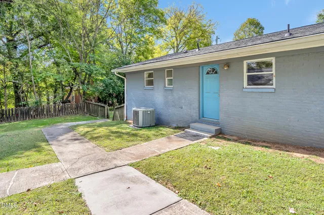 a backyard of a house with table and chairs