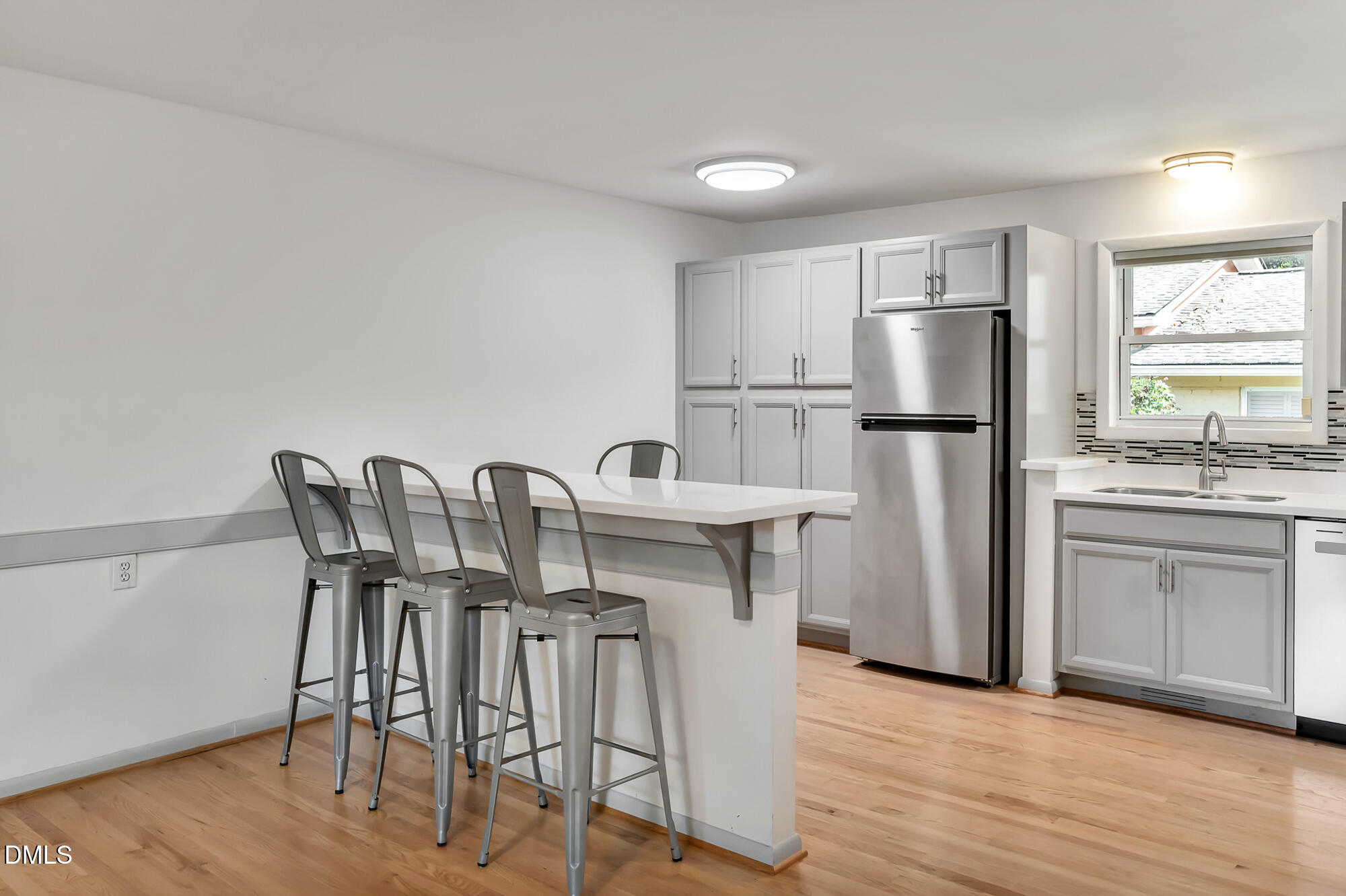 103 Hargraves Street, Unit K Carrboro, NC 27510 - Photo 5 of 19 a kitchen with stainless steel appliances a dining table chairs a refrigerator and cabinets