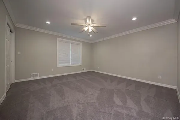 a view of an empty room with a ceiling fan