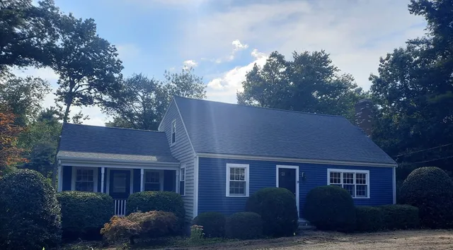 a front view of a house with a yard and tree s