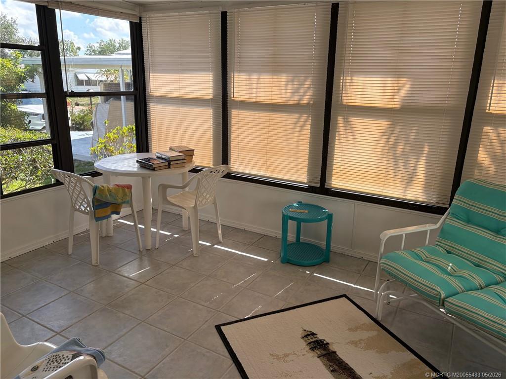 2856 Southwest Toronado Trail Stuart, FL 34997 - Photo 12 of 20 a table and chair sitting in a room next to a window