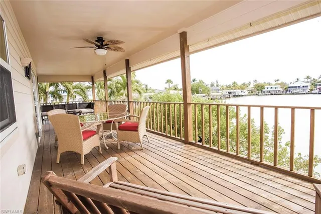 a view of a balcony with wooden floor and outdoor seating