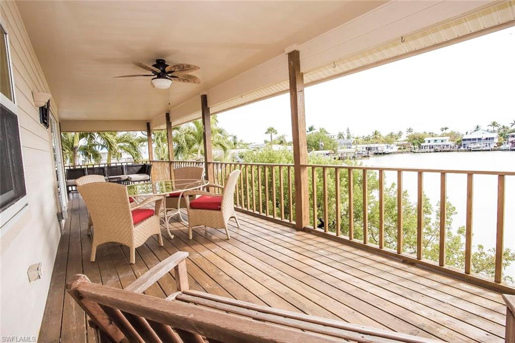 604 Sunset Court Goodland, FL 34140 - Photo 12 of 14 a view of a balcony with wooden floor and outdoor seating
