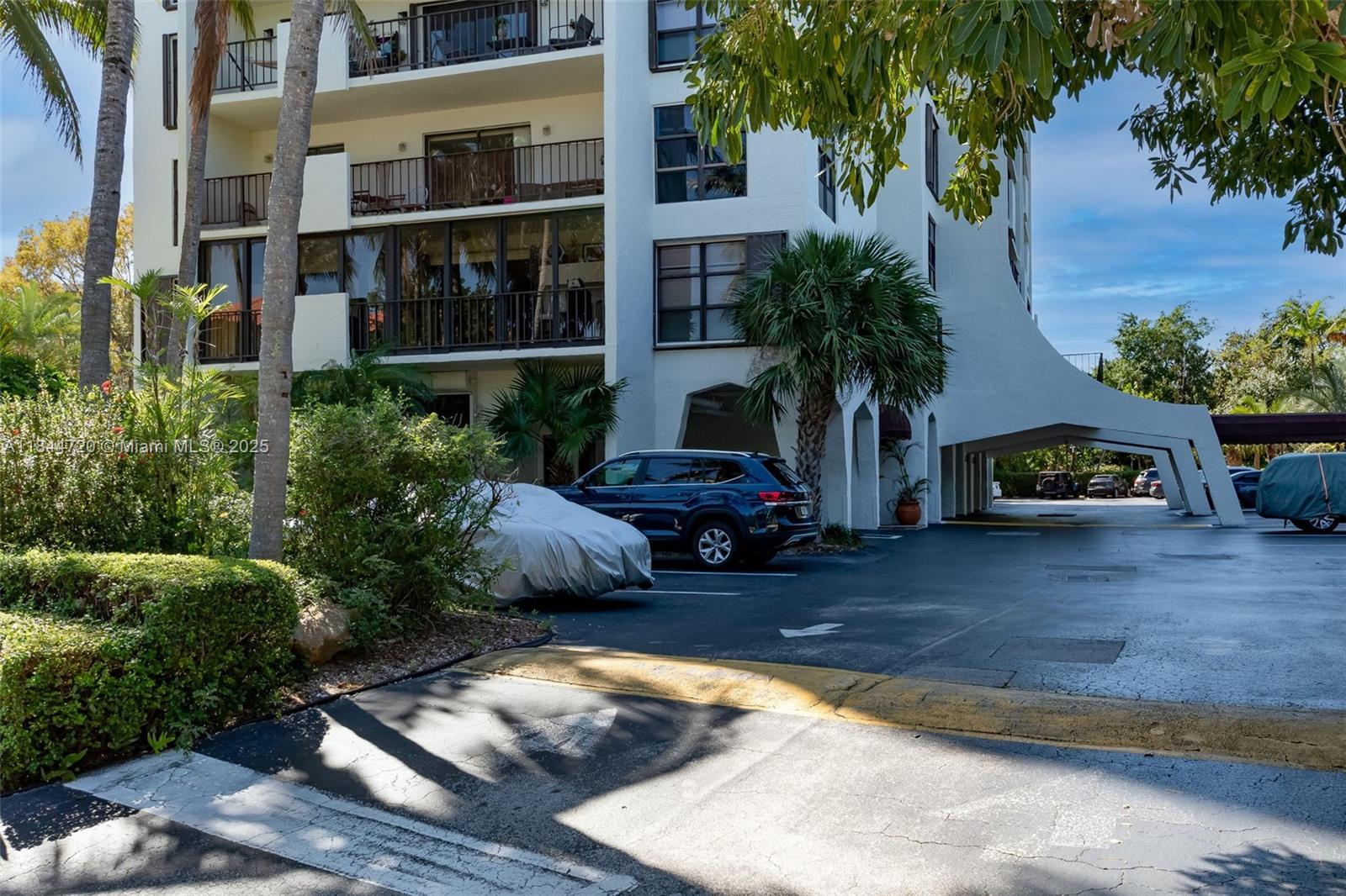 77 Crandon Boulevard, Unit 5B Key Biscayne, FL 33149 - Photo 2 of 41 a view of a house with a patio and a yard