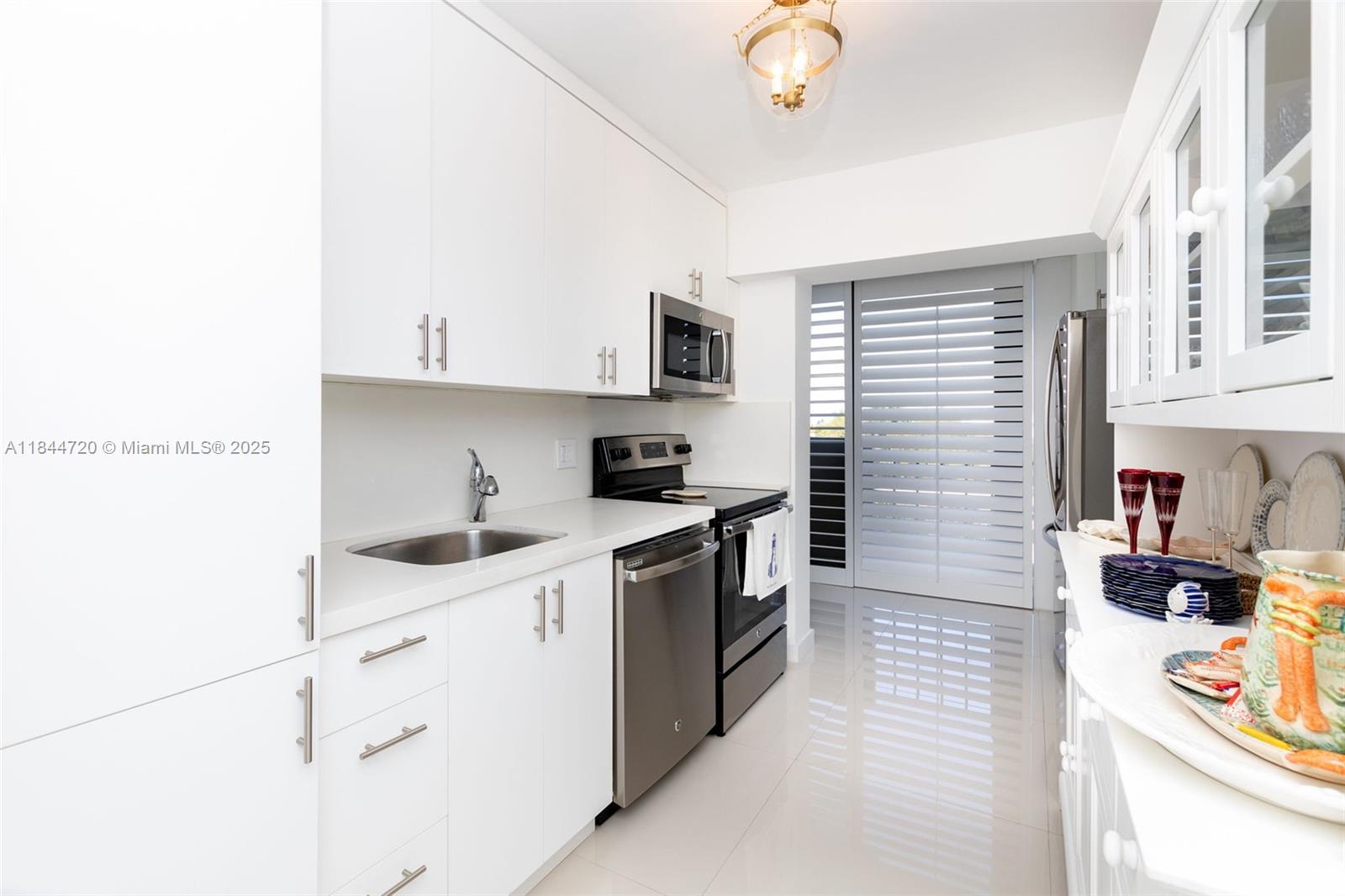 77 Crandon Boulevard, Unit 5B Key Biscayne, FL 33149 - Photo 25 of 41 a kitchen with stainless steel appliances granite countertop a sink and a stove