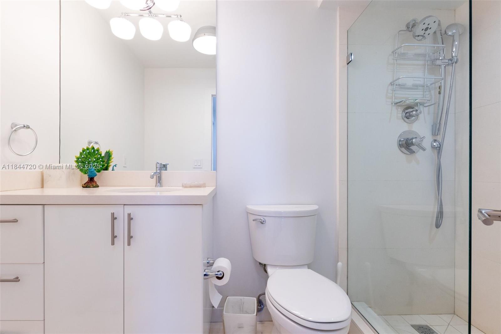 77 Crandon Boulevard, Unit 5B Key Biscayne, FL 33149 - Photo 30 of 41 a bathroom with a sink a toilet and shower