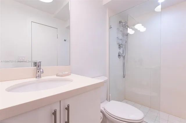 a bathroom with a shower a toilet and a sink