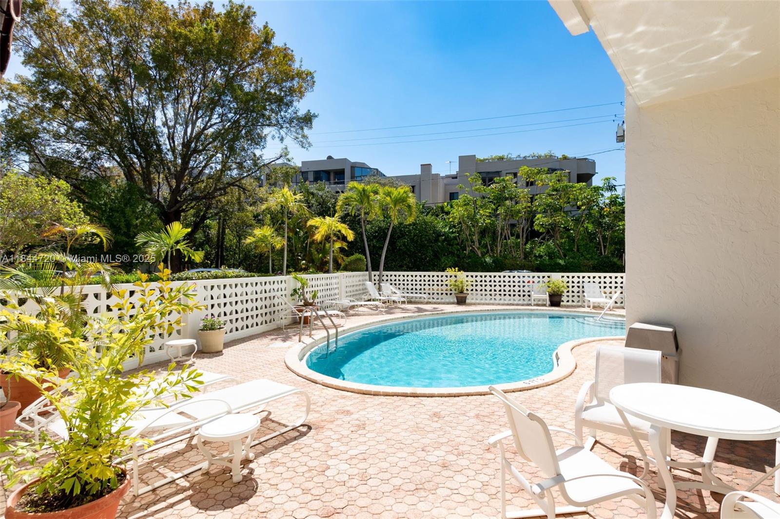 77 Crandon Boulevard, Unit 5B Key Biscayne, FL 33149 - Photo 37 of 41 a view of a swimming pool with a patio