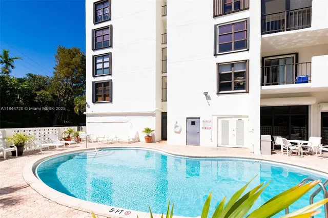 a view of a swimming pool with a dining table and chairs
