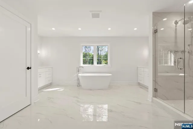 a spacious bathroom with a double vanity sink a toilet and a mirror