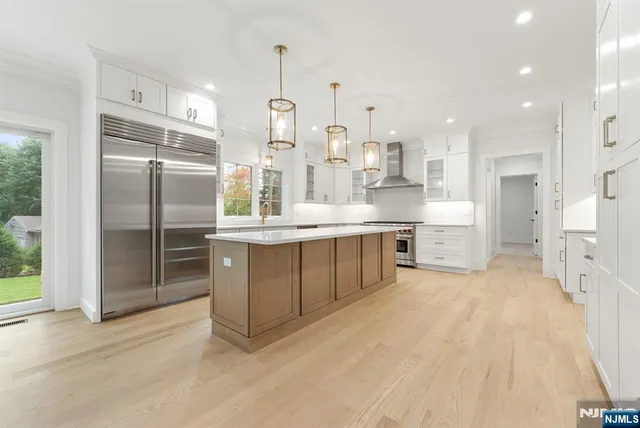 a large kitchen with kitchen island granite countertop a large counter top stainless steel appliances and windows