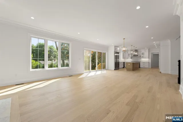 an empty room with windows and ceiling fan