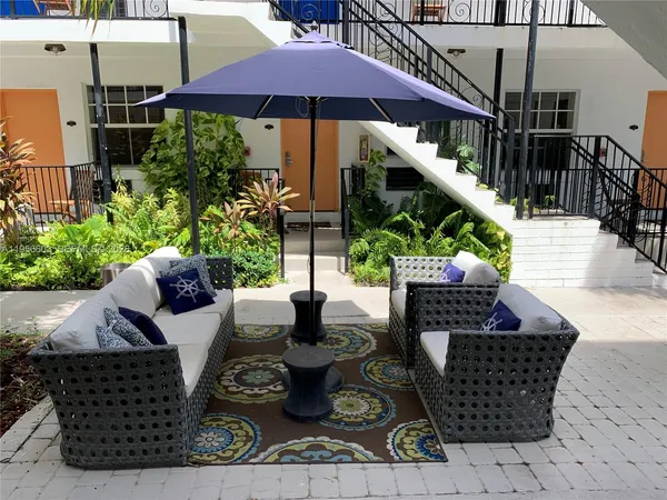 a view of a couches and dinning table with potted plants