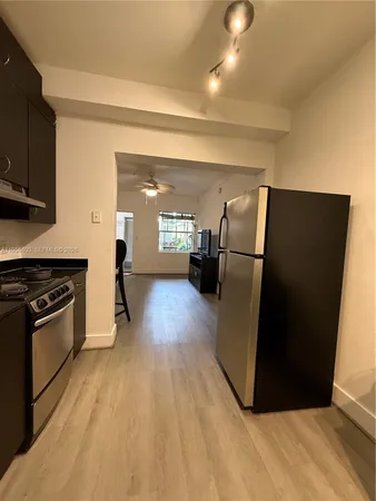 a kitchen with a refrigerator and a stove top oven