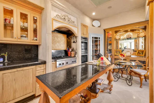 a kitchen with granite countertop a sink a counter top space cabinets and stainless steel appliances