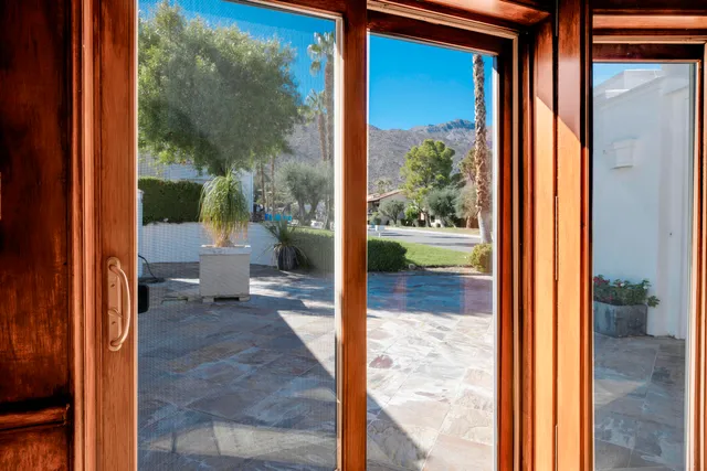 a view of a patio with chairs and potted plants
