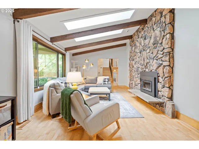 a living room with furniture a large window and a fireplace