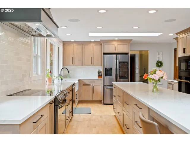 a large kitchen with granite countertop a sink stainless steel appliances and cabinets
