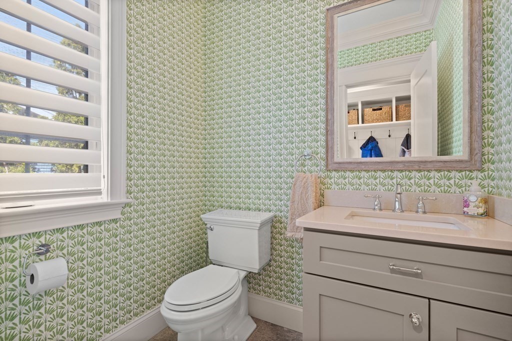 303 Hartman Road Newton, MA 02459 - Photo 14 of 39 a bathroom with a granite countertop toilet a sink a mirror and a window