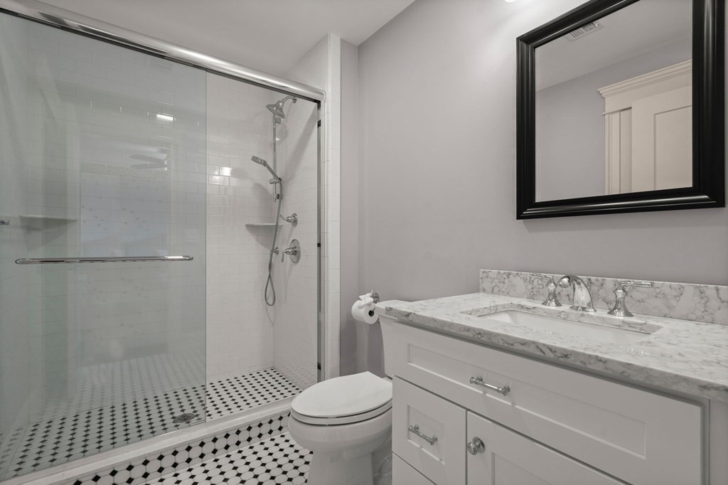 303 Hartman Road Newton, MA 02459 - Photo 22 of 39 a bathroom with a granite countertop sink a mirror and a toilet