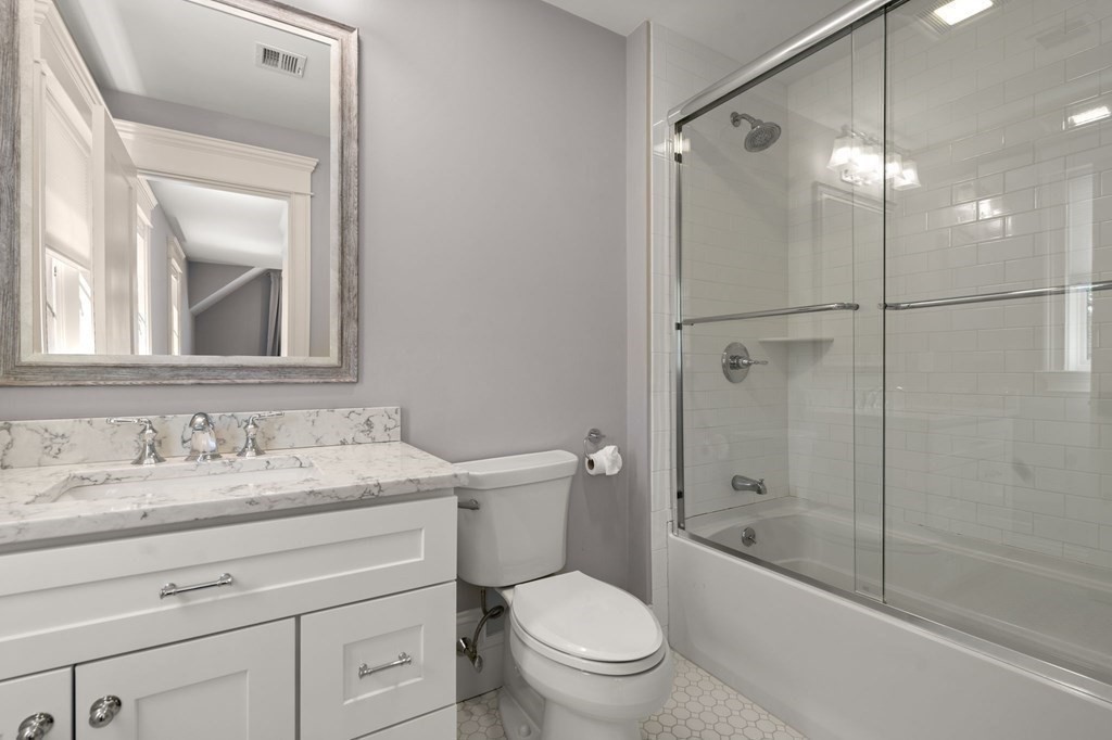 303 Hartman Road Newton, MA 02459 - Photo 24 of 39 a bathroom with a granite countertop toilet a sink and a bathtub