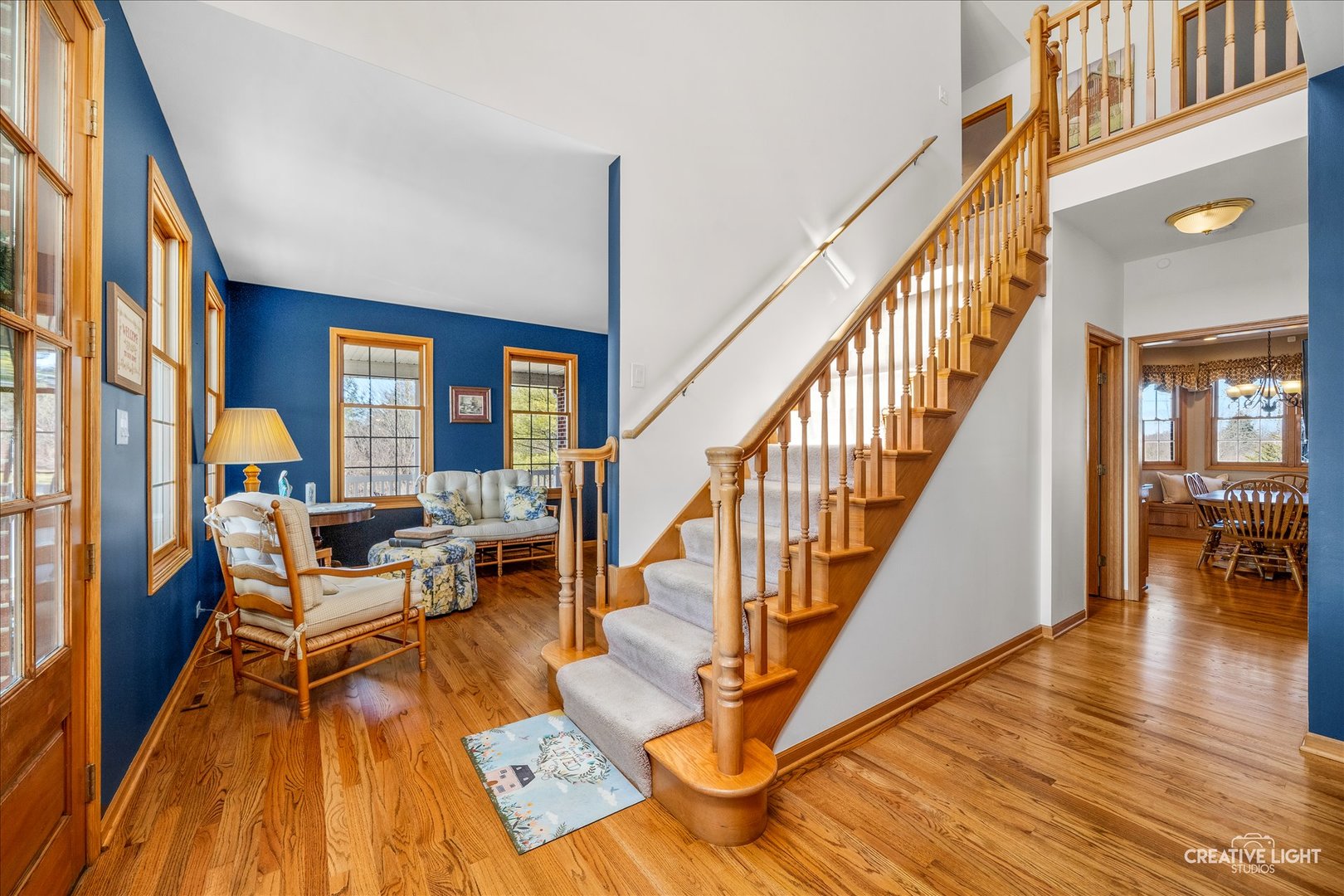 1651 Johnson Road Oswego, IL 60543 - Photo 13 of 60 a living room with wooden floors stairs and a dining table