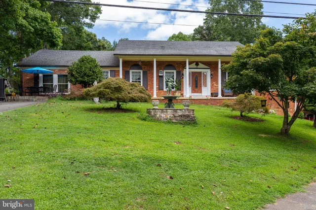 a view of a house with a yard and porch