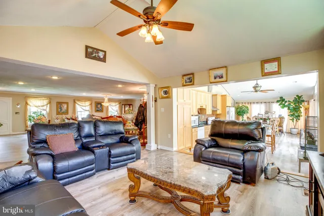 a living room with furniture a dining table and wooden floors