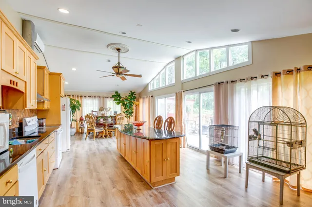 a kitchen with stainless steel appliances granite countertop a refrigerator a sink dishwasher and a stove with wooden floor