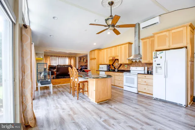 a living room with stainless steel appliances granite countertop furniture and a large window