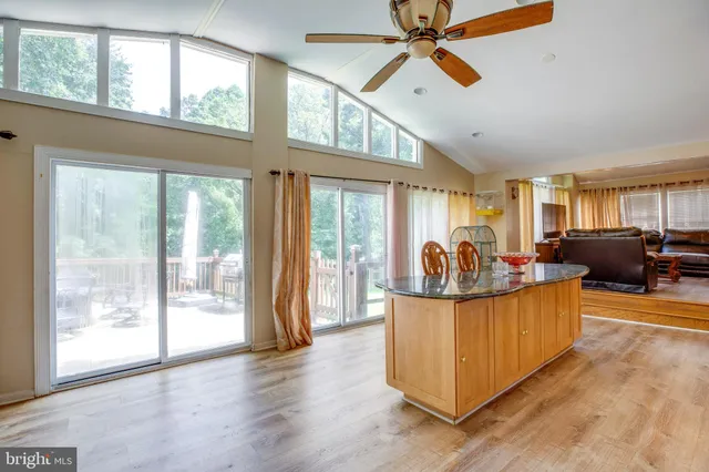 a kitchen with stainless steel appliances granite countertop a stove a sink and white cabinets with wooden floor