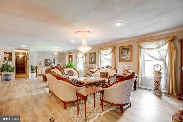 a living room with furniture a chandelier and a flat screen tv