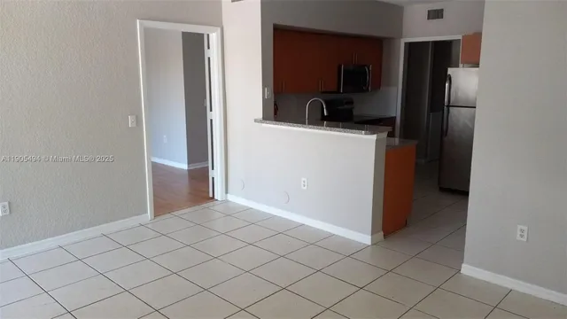 a kitchen with a refrigerator sink and cabinets