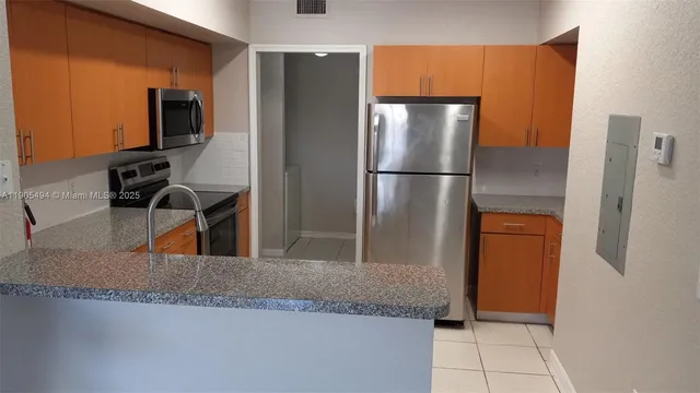 a kitchen with stainless steel appliances granite countertop a refrigerator and a sink