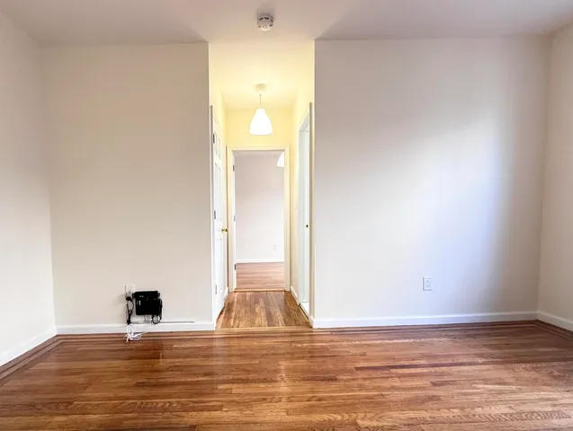 a view of empty room with wooden floor