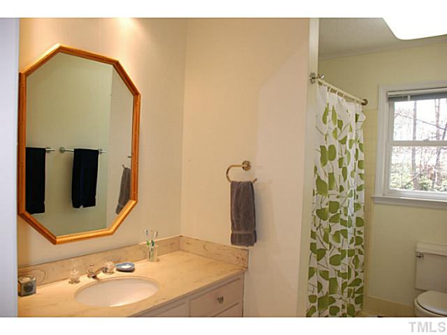1507 Stonehurst Road Raleigh, NC 27607 - Photo 14 of 23 a bathroom with a sink and a mirror