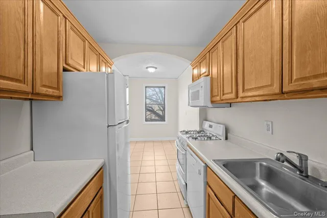 a kitchen with stainless steel appliances granite countertop a sink a stove and a refrigerator