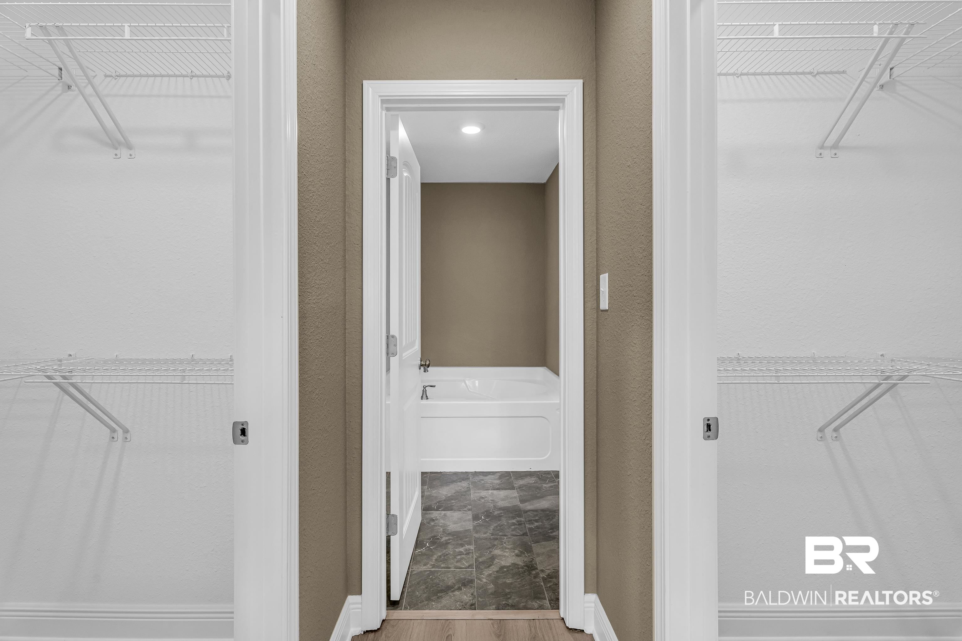 9206 Greenleaf Drive Daphne, AL 36527 - Photo 15 of 32 Full bathroom featuring a spacious closet, wood finished floors, a textured wall, and a bath